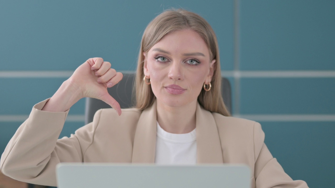 女商人在办公室使用笔记本电脑时显示大拇指向下的特写视频素材