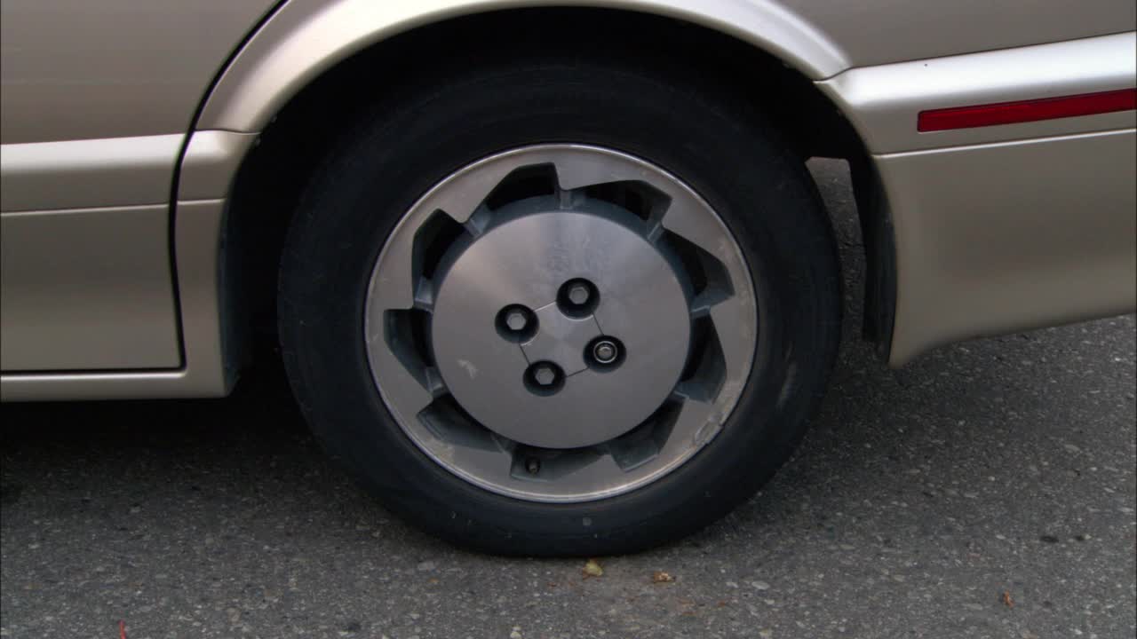 棕色或灰色轿车轮胎的特写角度。波夫开始从右向左平移汽车。轮子。轮圈。轮毂视频下载