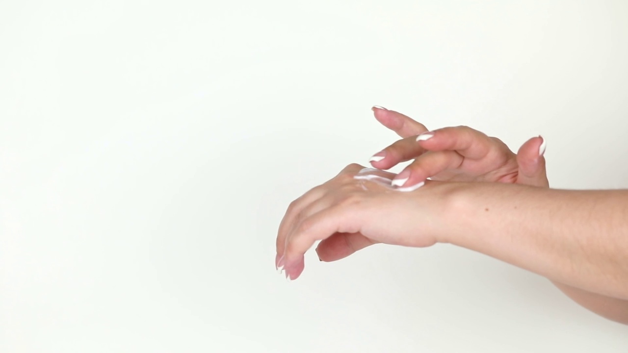 在一个浅色的背景上，手指叫手上的奶油视频素材