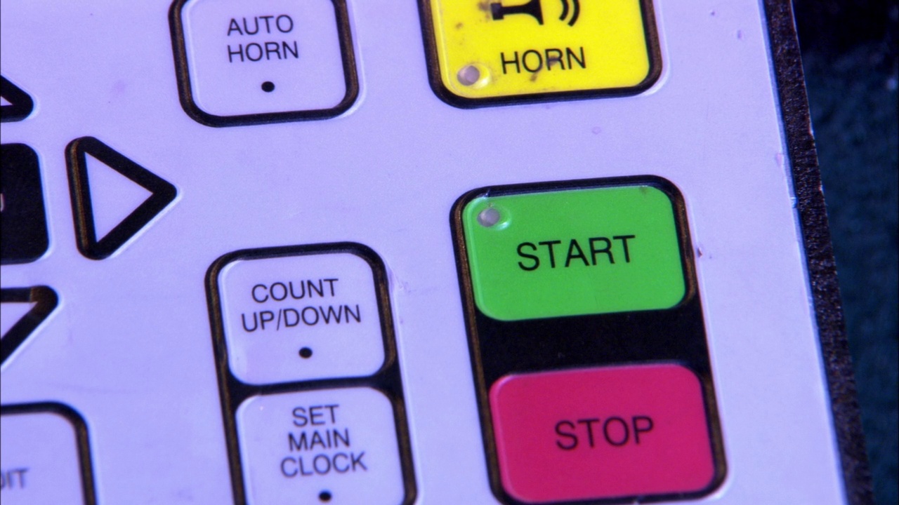 记分牌控制面板的关闭角度，有“自动喇叭”、“喇叭”、“启动”、“停止”、“向上/向下计数”、“主时钟”等按钮。可能是在打篮球，冰球。体育视频下载