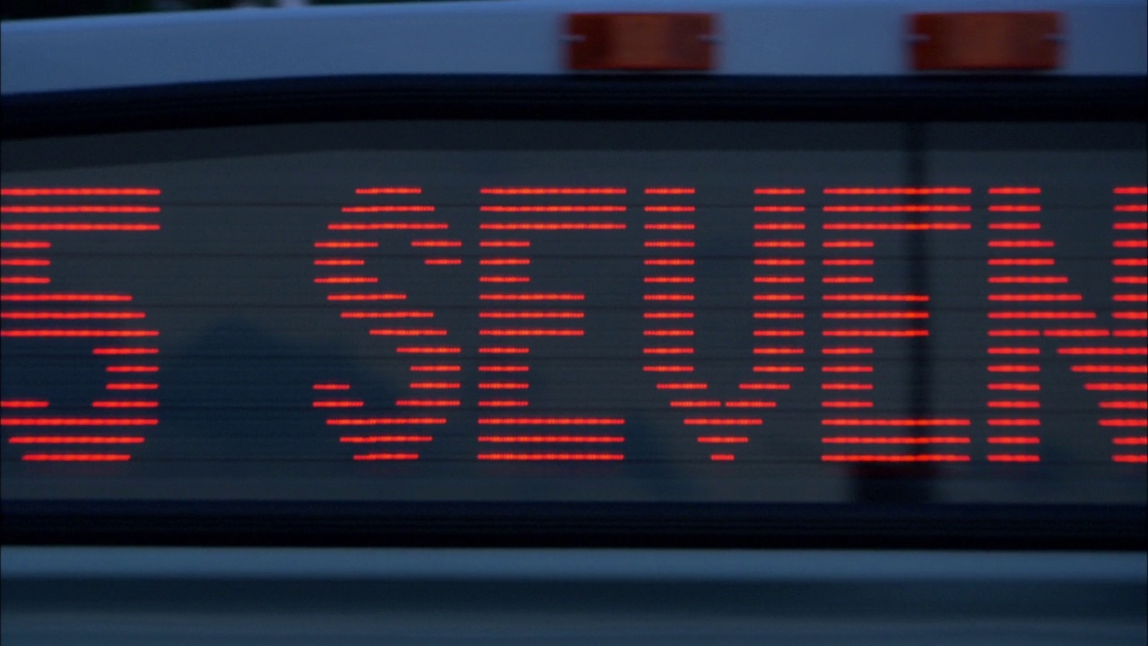 从左到右潘中角的城市巴士招牌上写着“45七。”随着镜头的移动，路线标志变成了“大河”。黑色背景下的橙色字母视频素材