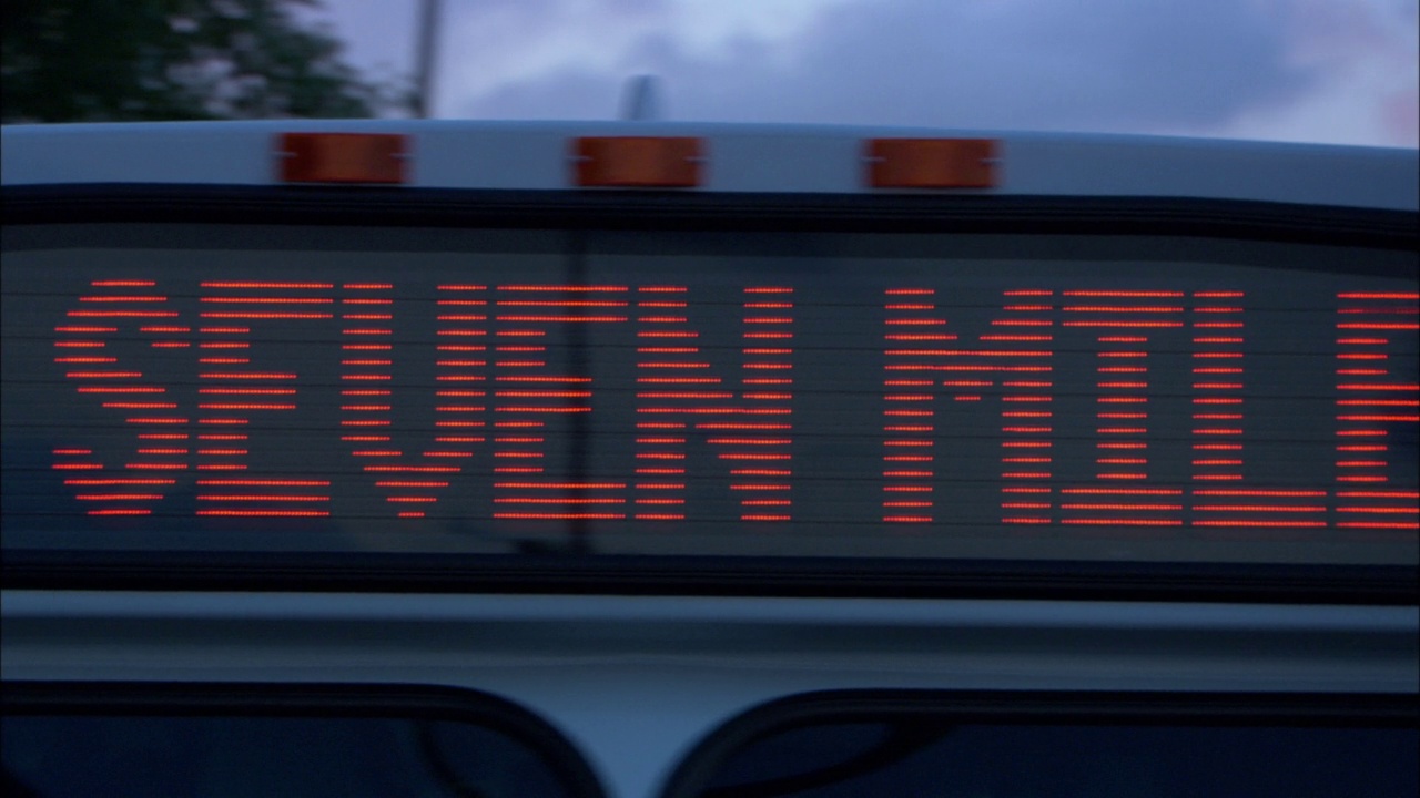 从左到右潘中角的城市巴士招牌上写着“45七。”随着镜头的移动，路线标志变成了“大河”。黑色背景下的橙色字母视频素材