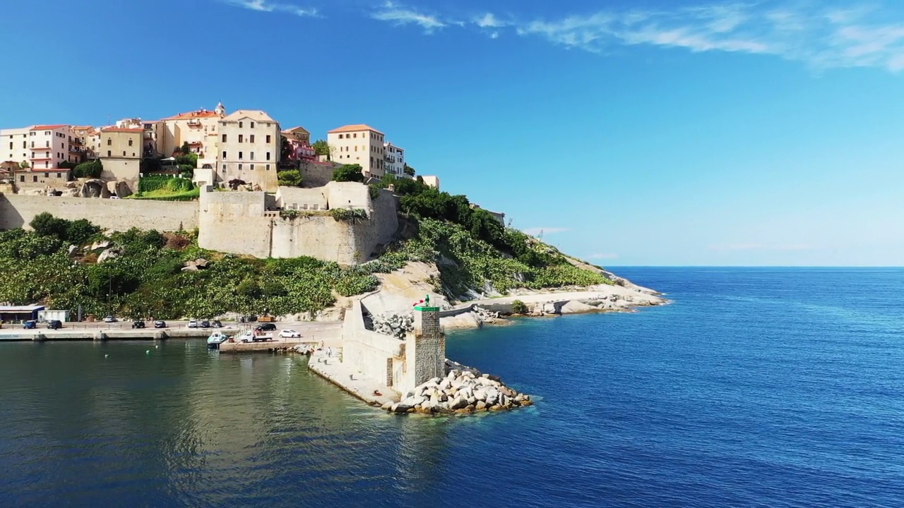 在欧洲，法国，科西嘉岛的港口入口处的灯塔和中世纪的堡垒，在地中海边，夏天，阳光明媚的日子。视频下载