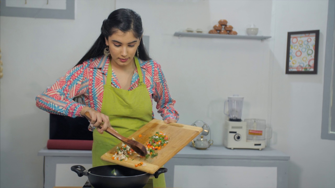 一位美丽的年轻女性为家人烹饪健康的食物——营养的食物，健康的食物，印度厨房，年轻的职业女性视频素材