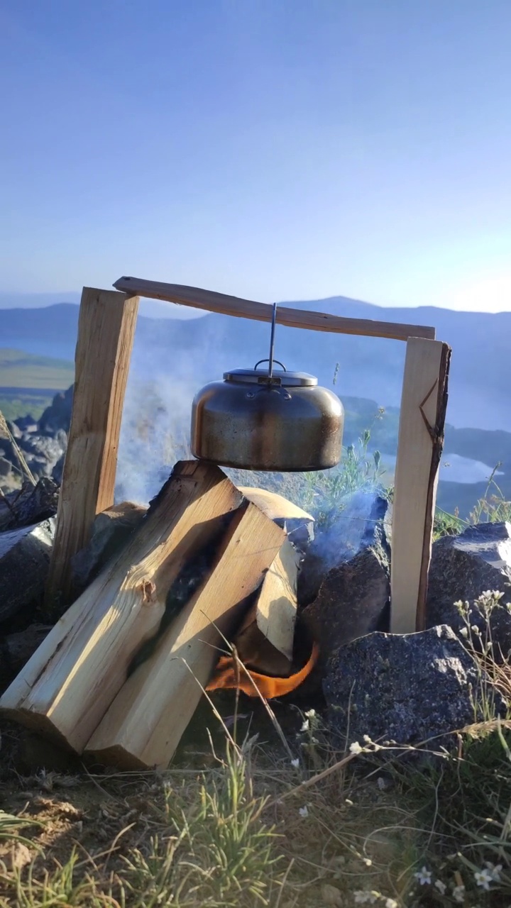 一个可爱的老式茶壶在湖边露营地的镜头视频素材