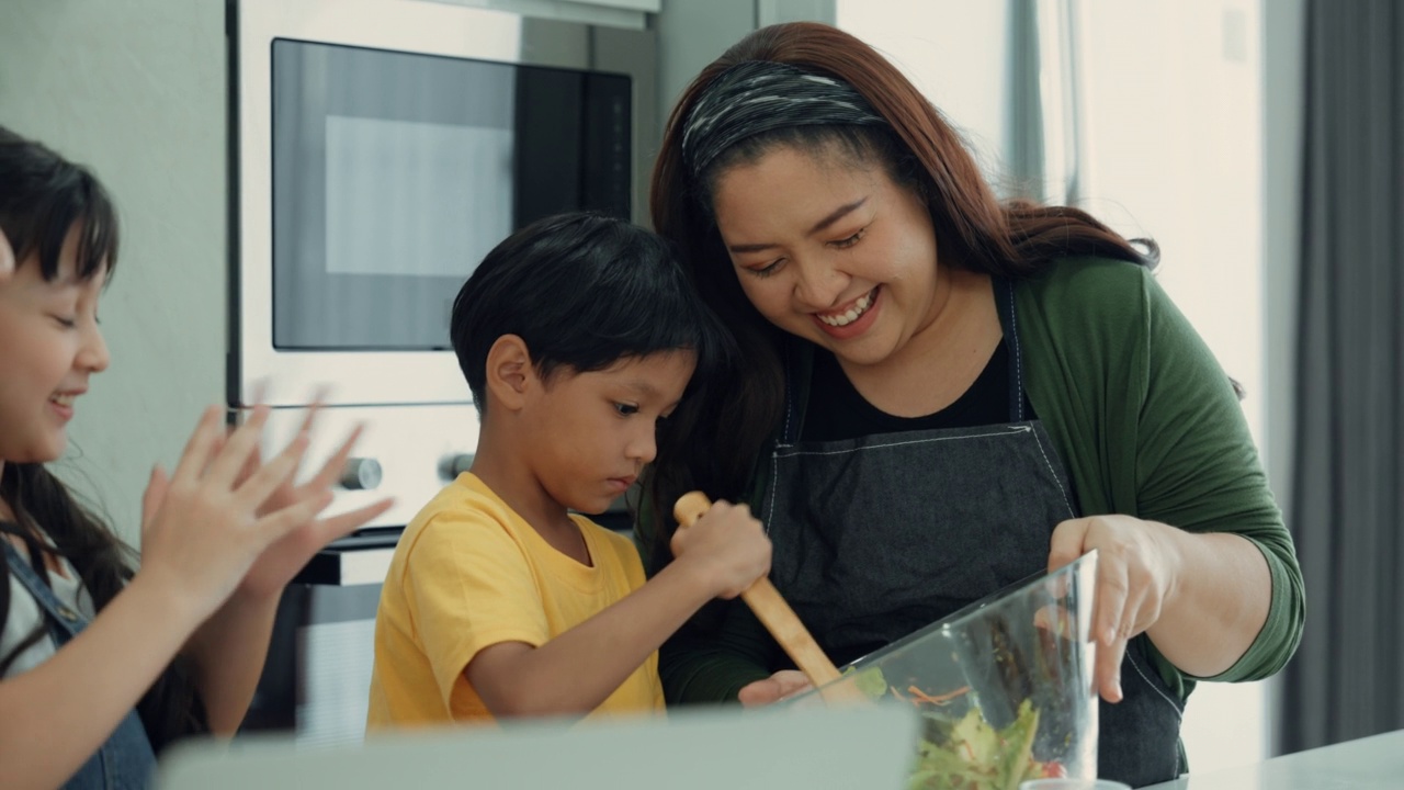 亚洲家庭在厨房一起烹饪视频素材