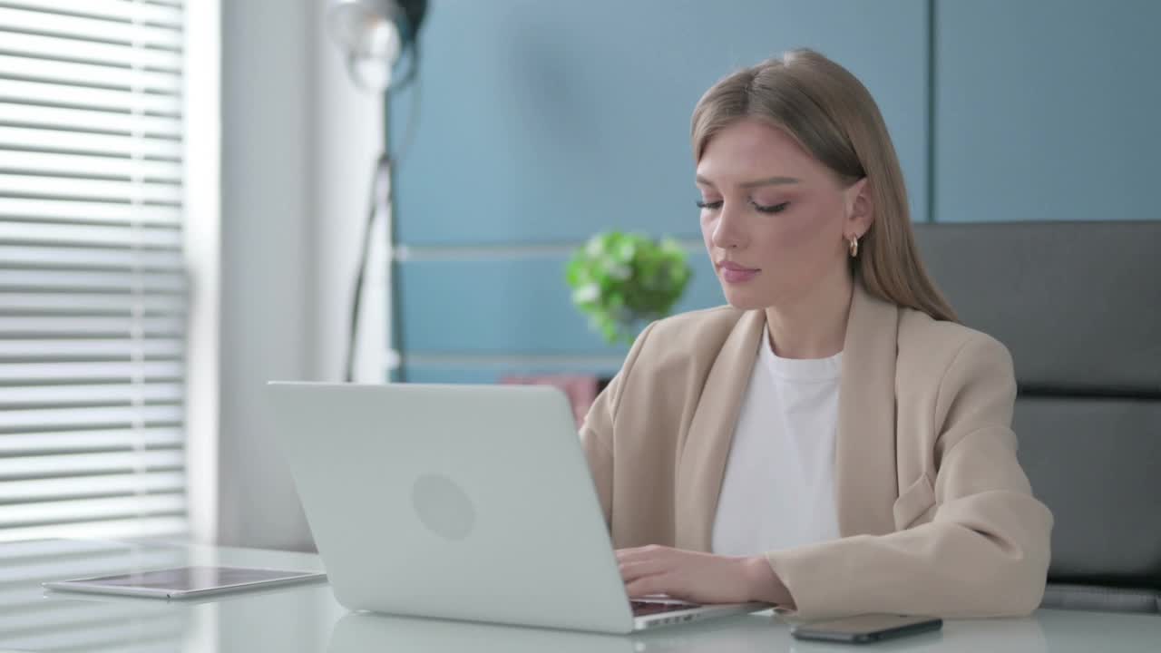 女商人在办公室使用笔记本电脑时竖起大拇指视频素材