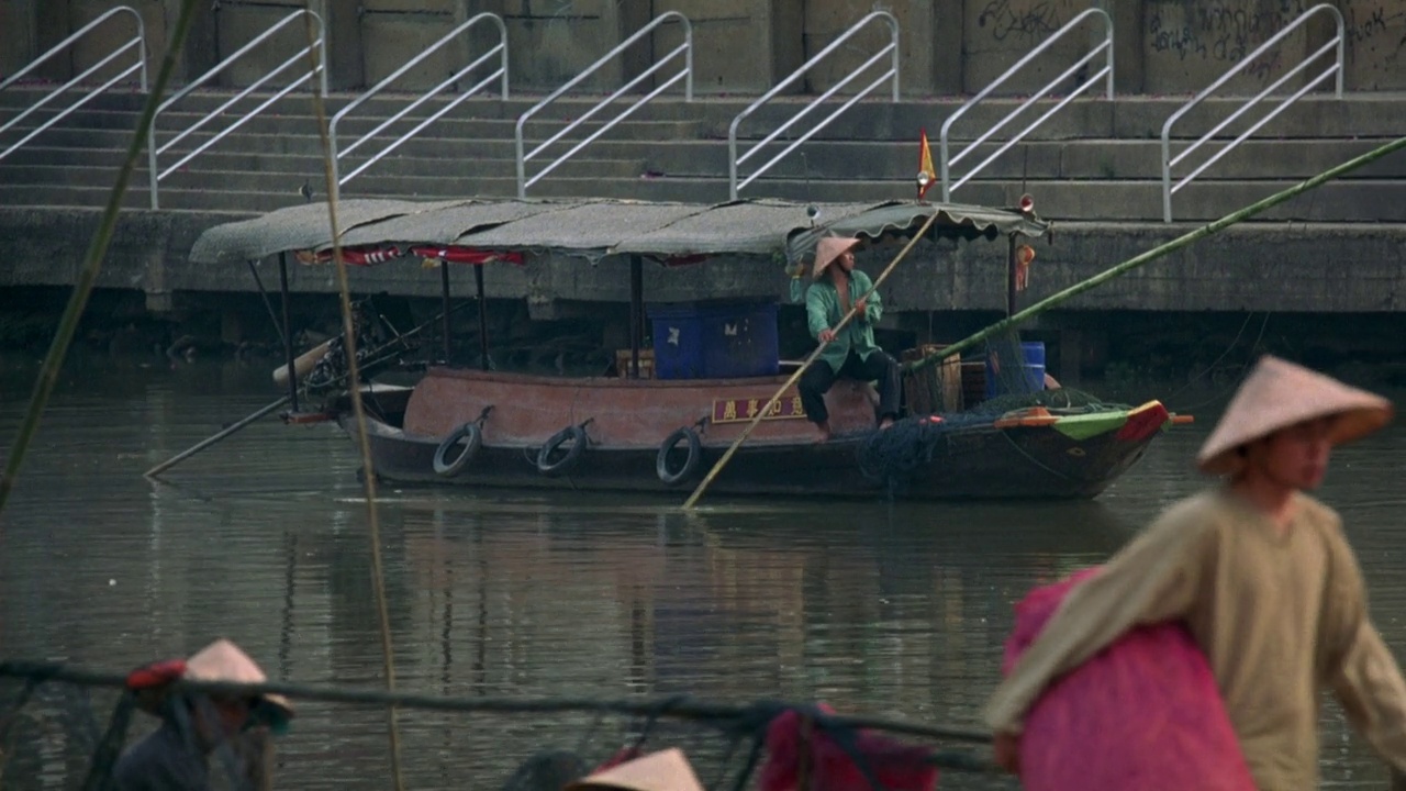 西贡附近港区角度中等。楼梯在岸上。船，人用篙或桨在水里。小艇。小码头上的人准备就绪。可能是钓鱼，渔民视频素材