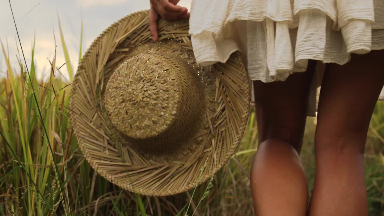 戴着草帽的无忧无虑的女人走在稻田里视频下载