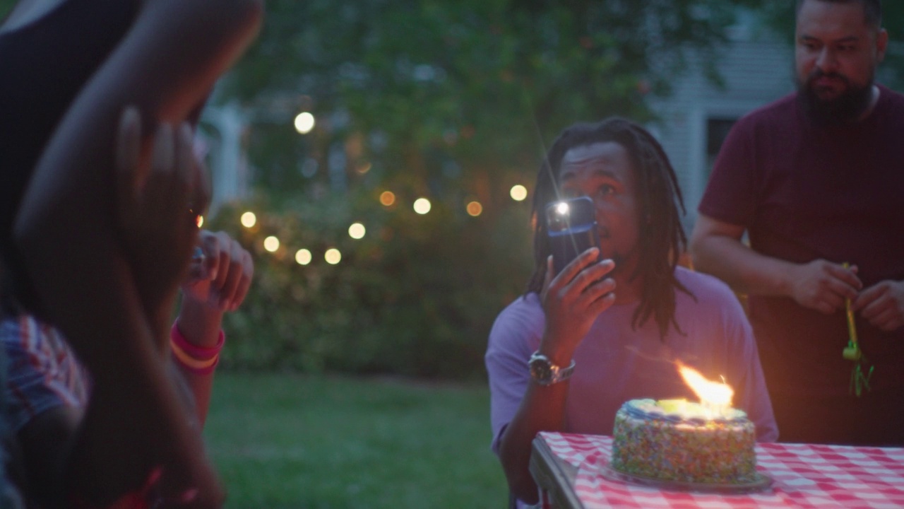 在聚会上，女友帮男友吹灭生日蜡烛视频素材