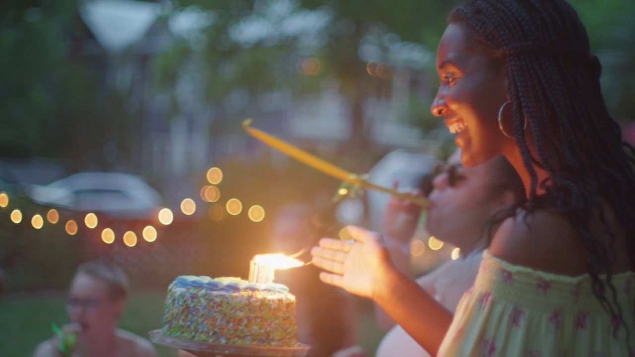 在生日聚会上，女人带着生日蛋糕给朋友视频素材