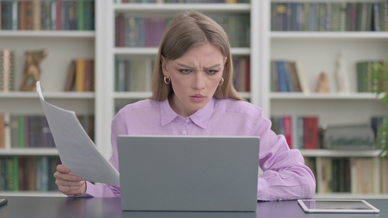 带着笔记本电脑的女人在阅读文件时会丢失视频素材
