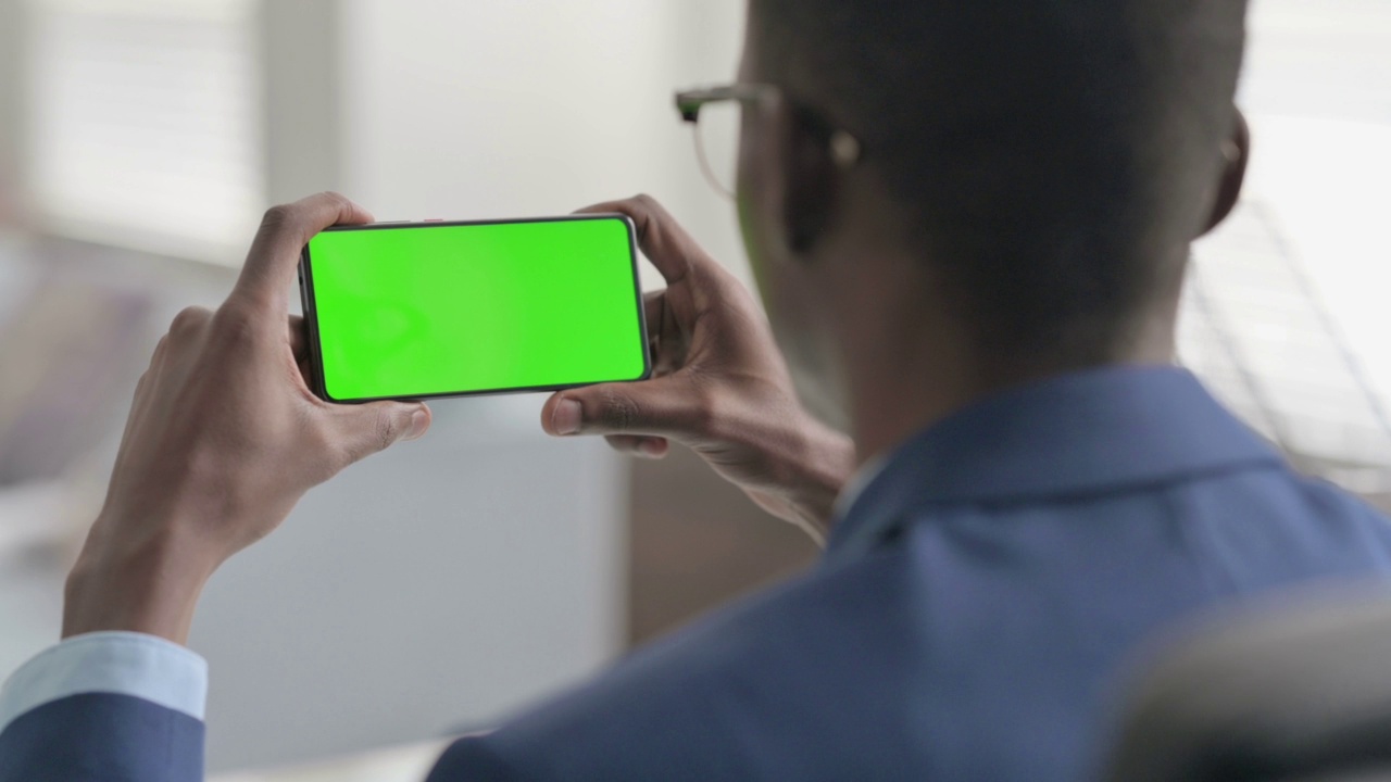 年轻的非洲商人用Chroma屏幕看智能手机视频素材