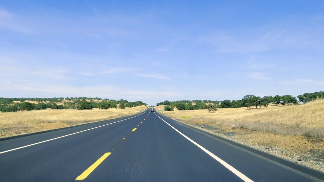 透过汽车挡风玻璃看到的加州高速公路。在炎热的晴天，在沙漠中的高速公路上开车。汽车反射在挡风玻璃上。视频下载