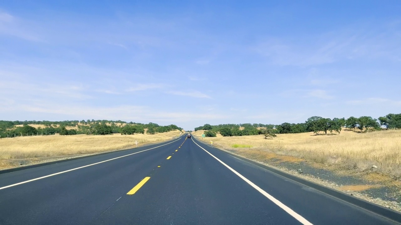 透过汽车挡风玻璃看到的加州高速公路。在炎热的晴天，在沙漠中的高速公路上开车。汽车反射在挡风玻璃上。视频下载