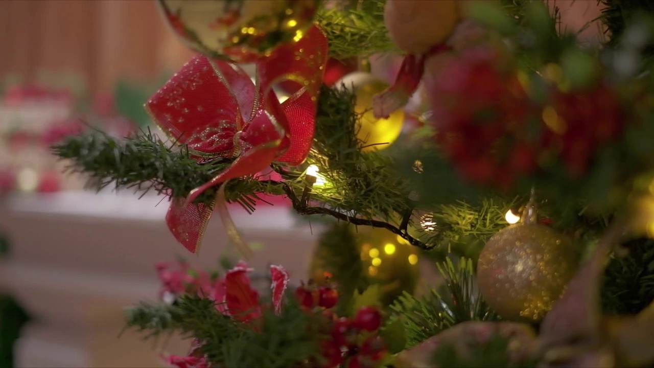 圣诞树上的红色蝴蝶结和闪闪发光的圣诞花环。视频素材