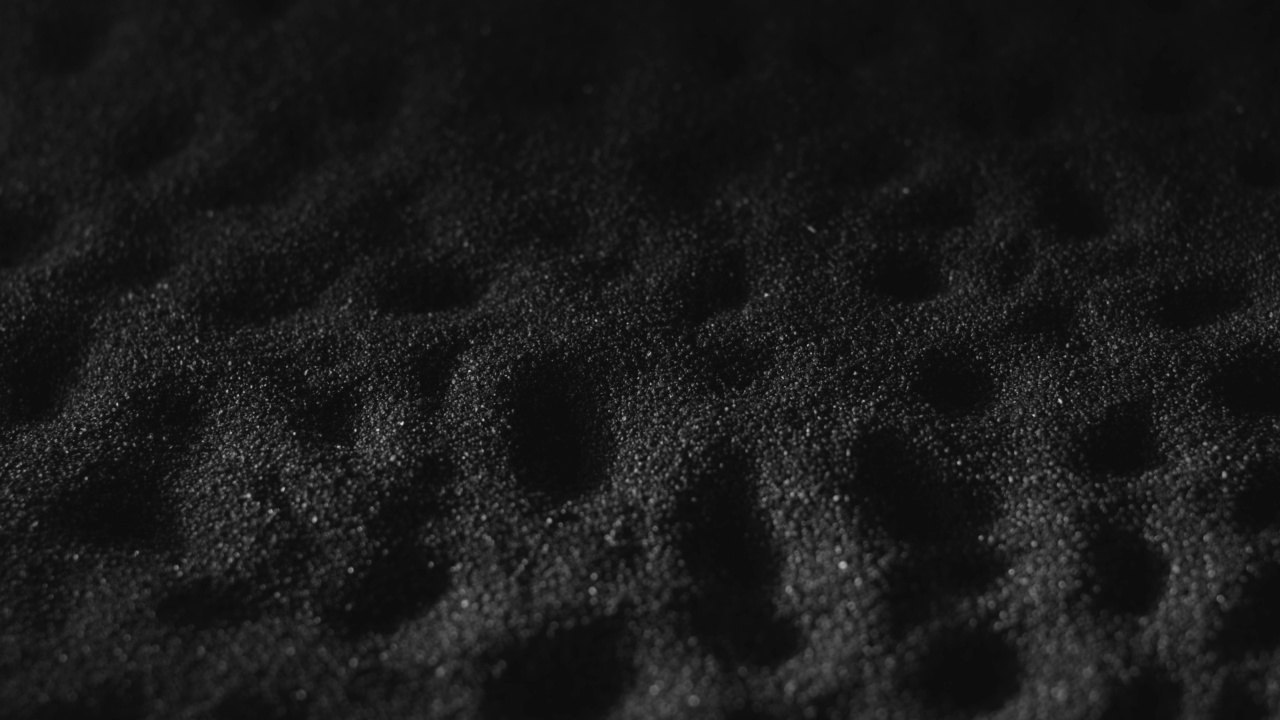 黑色砂表面有酒窝。单色纹理背景的黑色海滩沙子。火药、粒度的尘埃视频素材