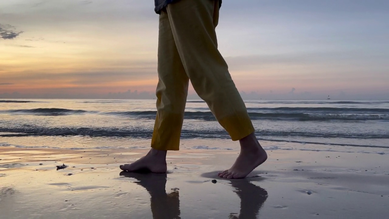 近光脚的女人走在海滩上的日出在早晨视频下载