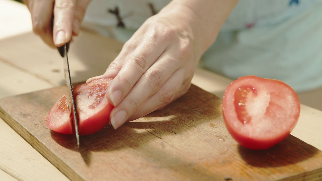 在砧板上切西红柿。视频素材