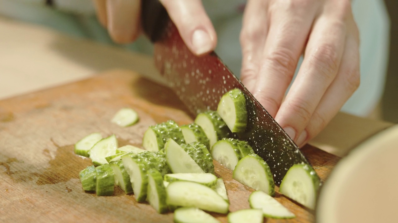 在菜板上切黄瓜。视频素材