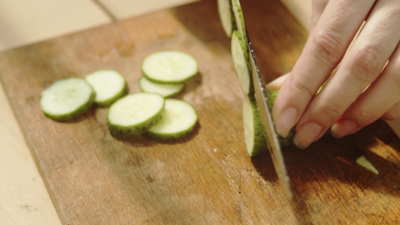 在菜板上切黄瓜。视频素材
