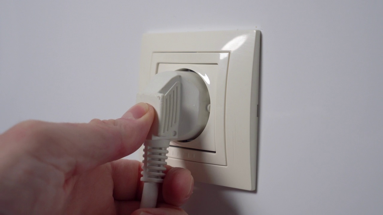 把电源插头插在白色家庭墙上的电源插座上。连接关闭视频素材