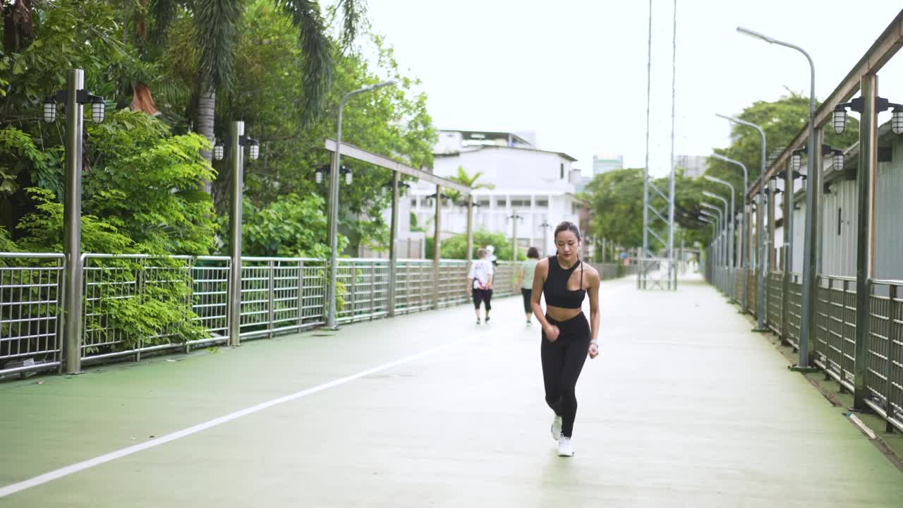 运动女性在公园用智能手表监测自己的跑步表现视频素材