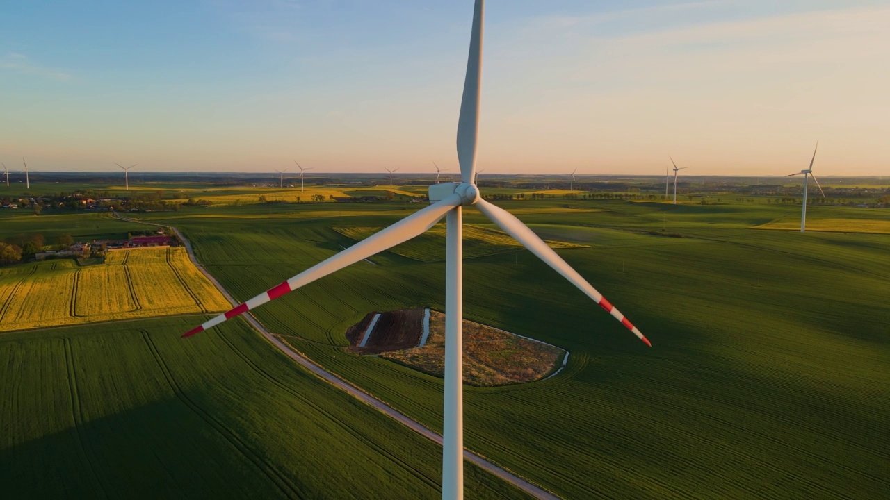 无人机特写的绿色技术风力涡轮机在晴天与草地史诗航拍视频素材
