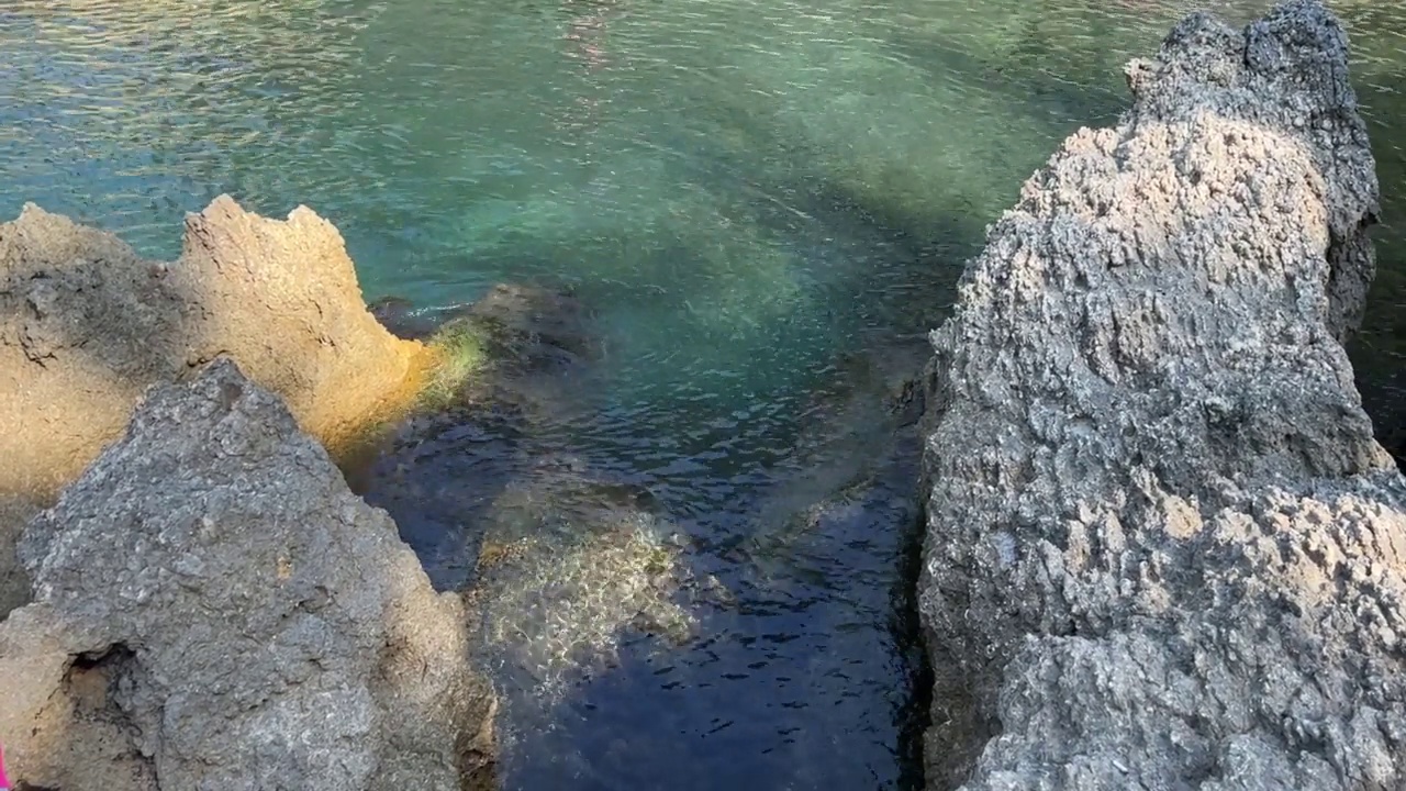 绿松石海泻湖在岩石海岸清澈的水。视频素材