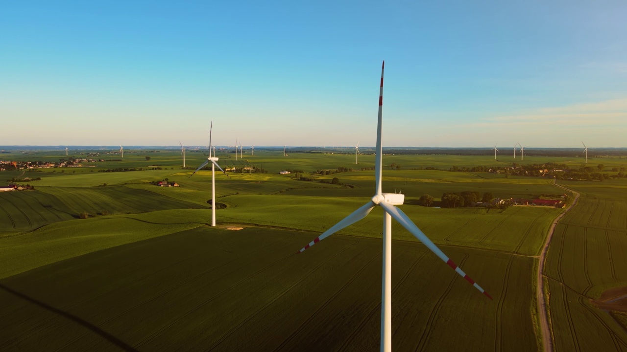 风车叶片在麦田中间快速旋转，产生可再生电能，保护环境视频素材