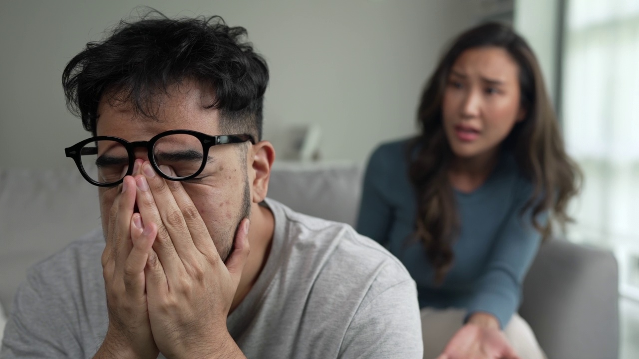 年轻的亚洲夫妇争吵大喊指责对方的问题，夫妻吵架在家里，关系问题的概念视频素材