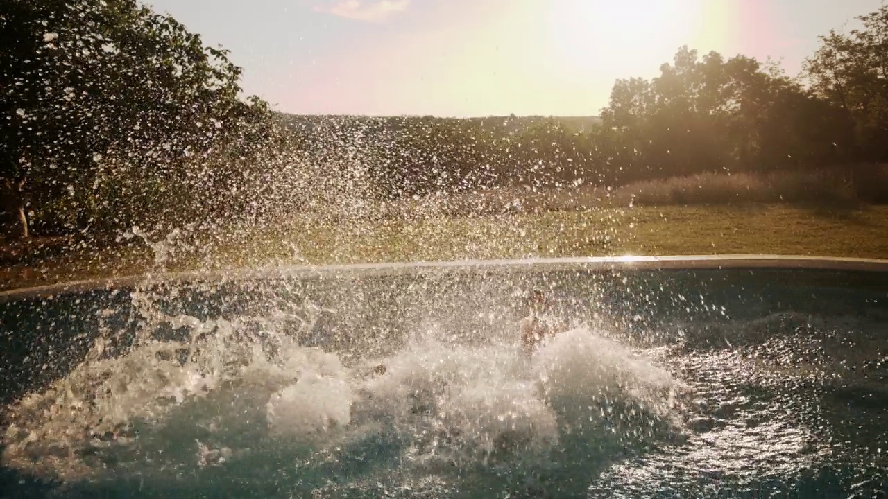 无忧无虑的一家人在后院的游泳池里跳跃视频素材