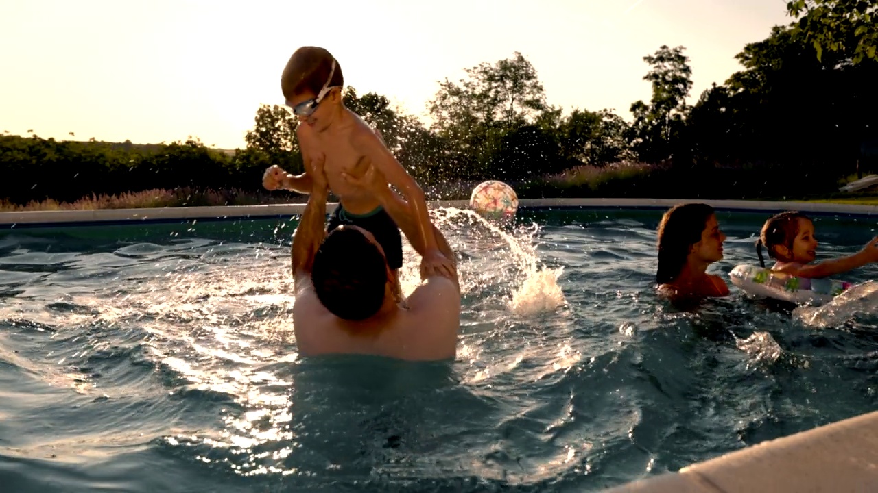 欢快的父母和孩子们在游泳池里玩得很开心视频素材