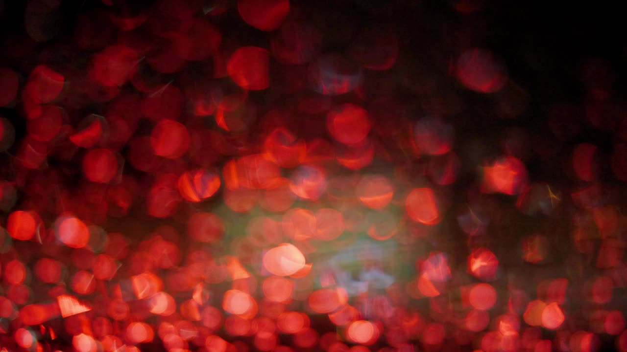 抽象背景与闪光的红色和金色闪光散景与雨在夜间背景。交通堵塞在下雨的白天在晚上的时间。视频下载
