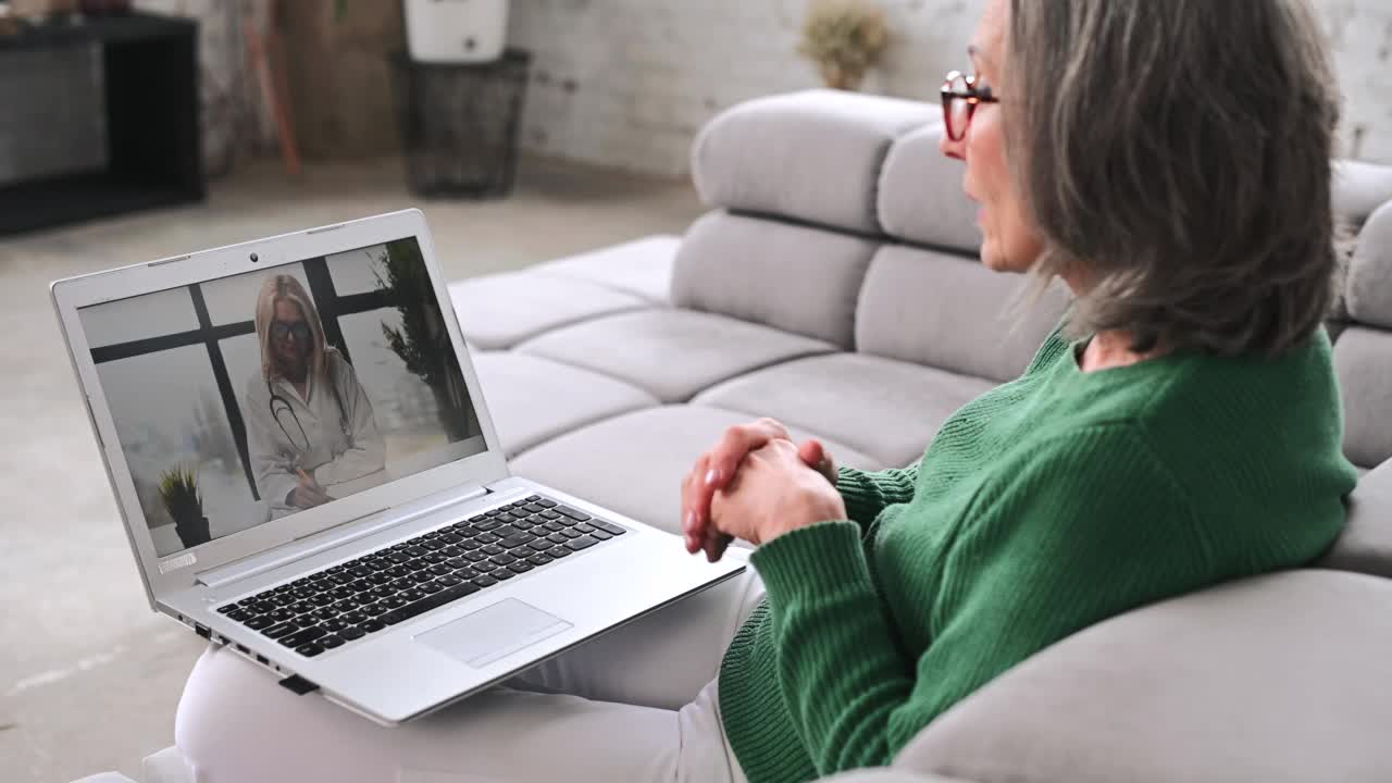 成熟的老年女性在家使用笔记本电脑视频素材