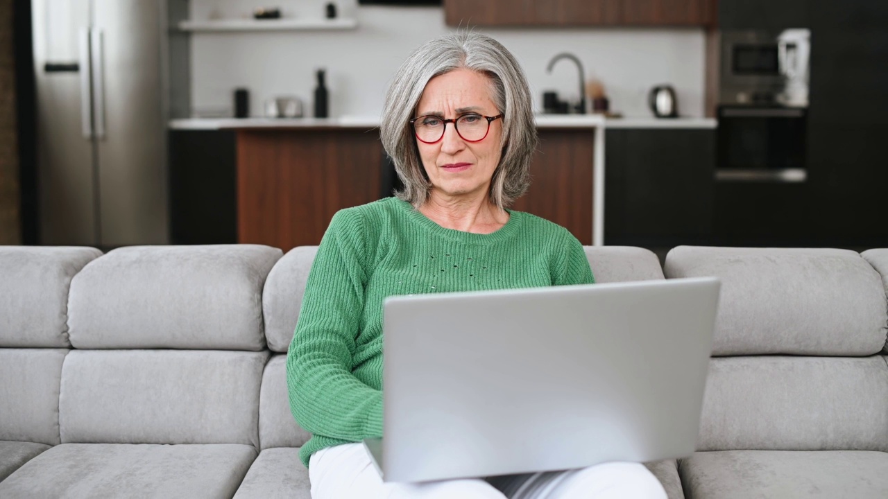 成熟的老年女性在家使用笔记本电脑视频素材