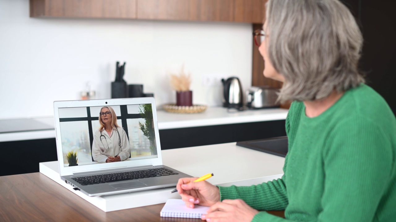 成熟的老年女性在家用笔记本电脑进行视频通话视频素材
