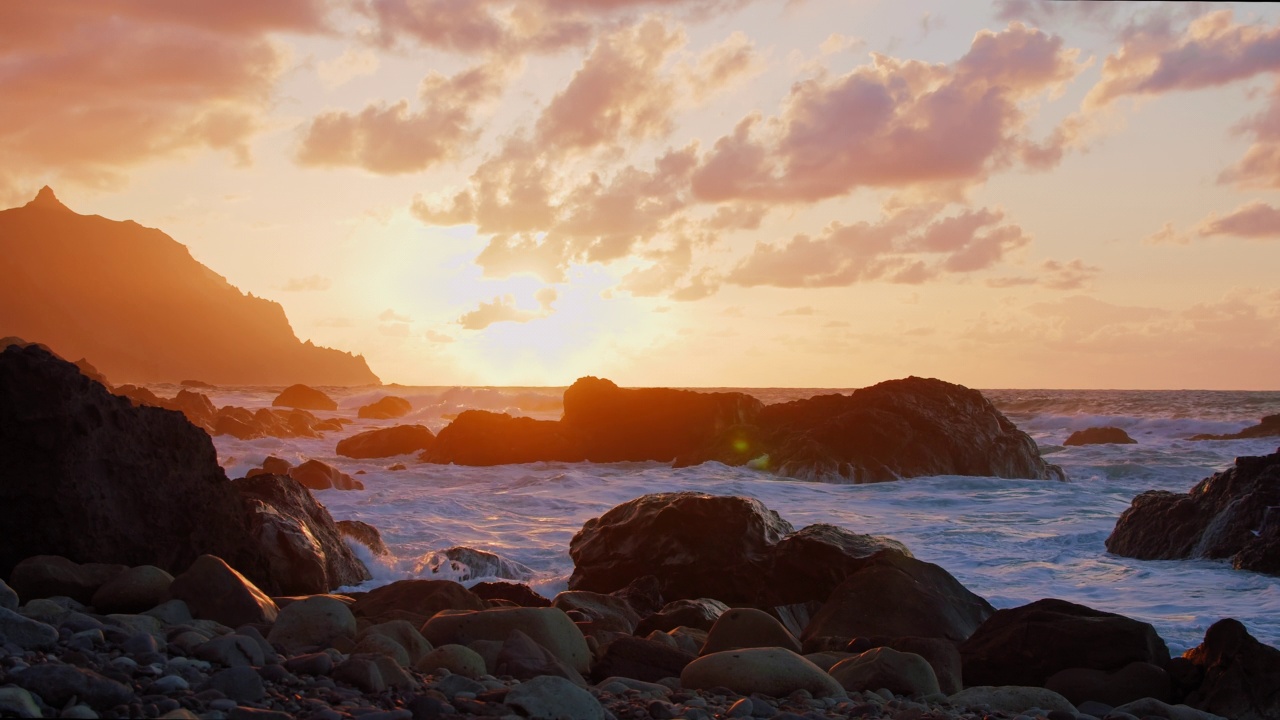 在特内里费北部海岸，汹涌的海浪冲击着岩石峭壁。日落时分，河水拍打在石头上。壮观的放松。视频素材