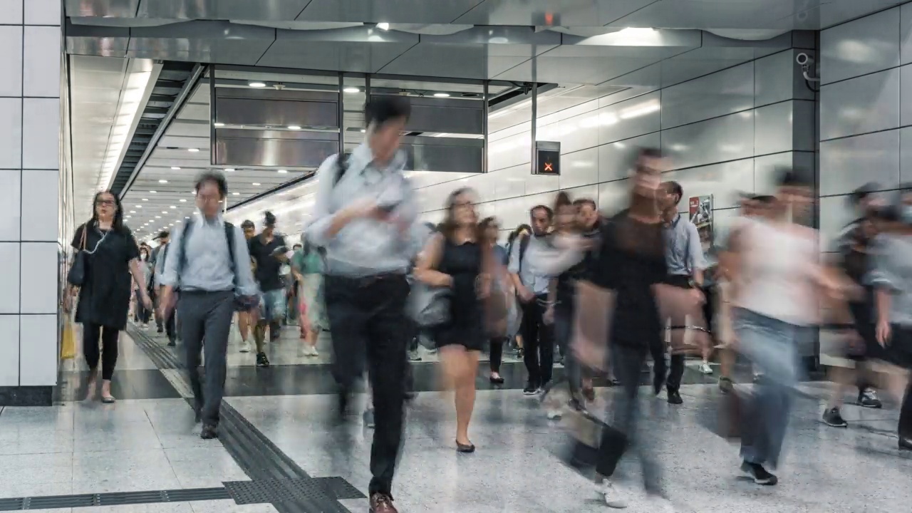 时间流逝的行人和商务人士在香港地铁高峰时段的车站行走视频素材