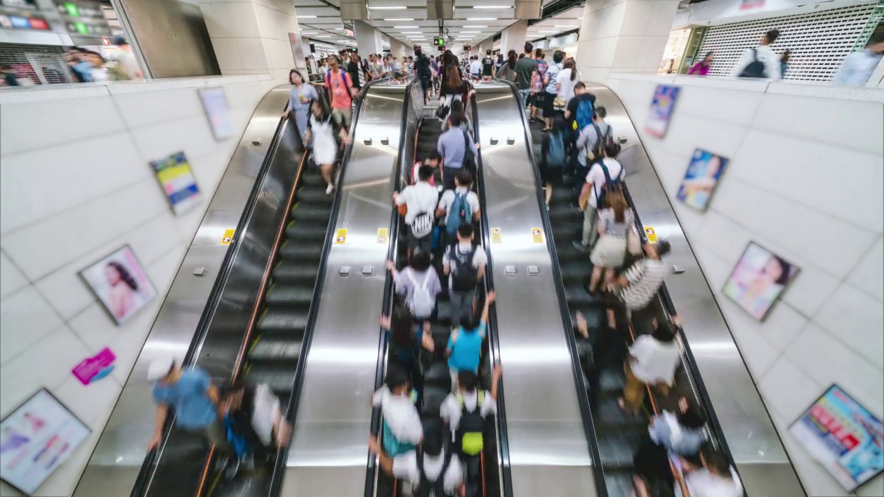 香港地铁高峰时段乘客与游客在自动扶梯上行走的时间视频素材
