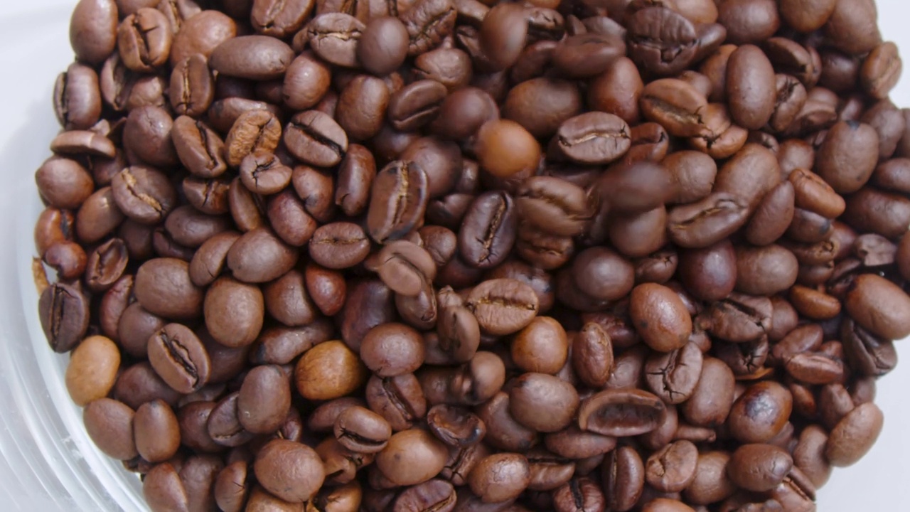 整个咖啡豆倒在容器中，以慢动作接近视频素材