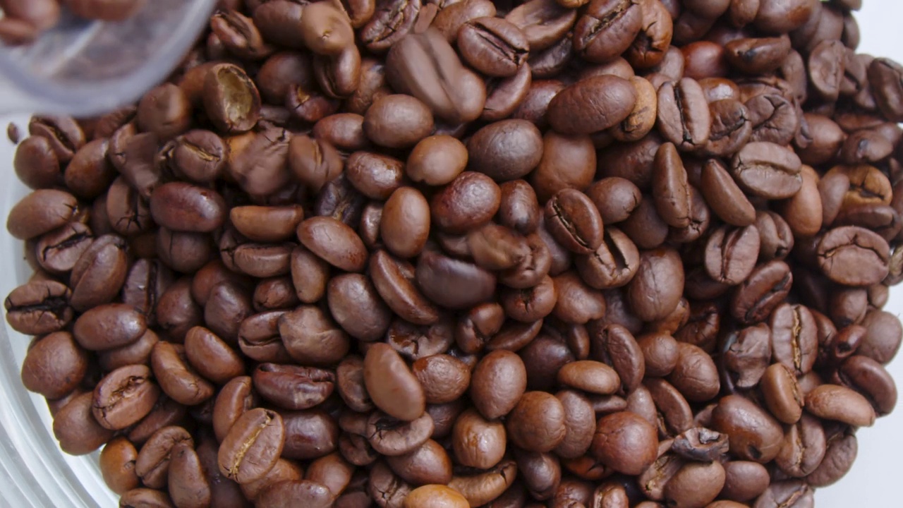 整个咖啡豆倒在容器中，以慢动作接近视频素材