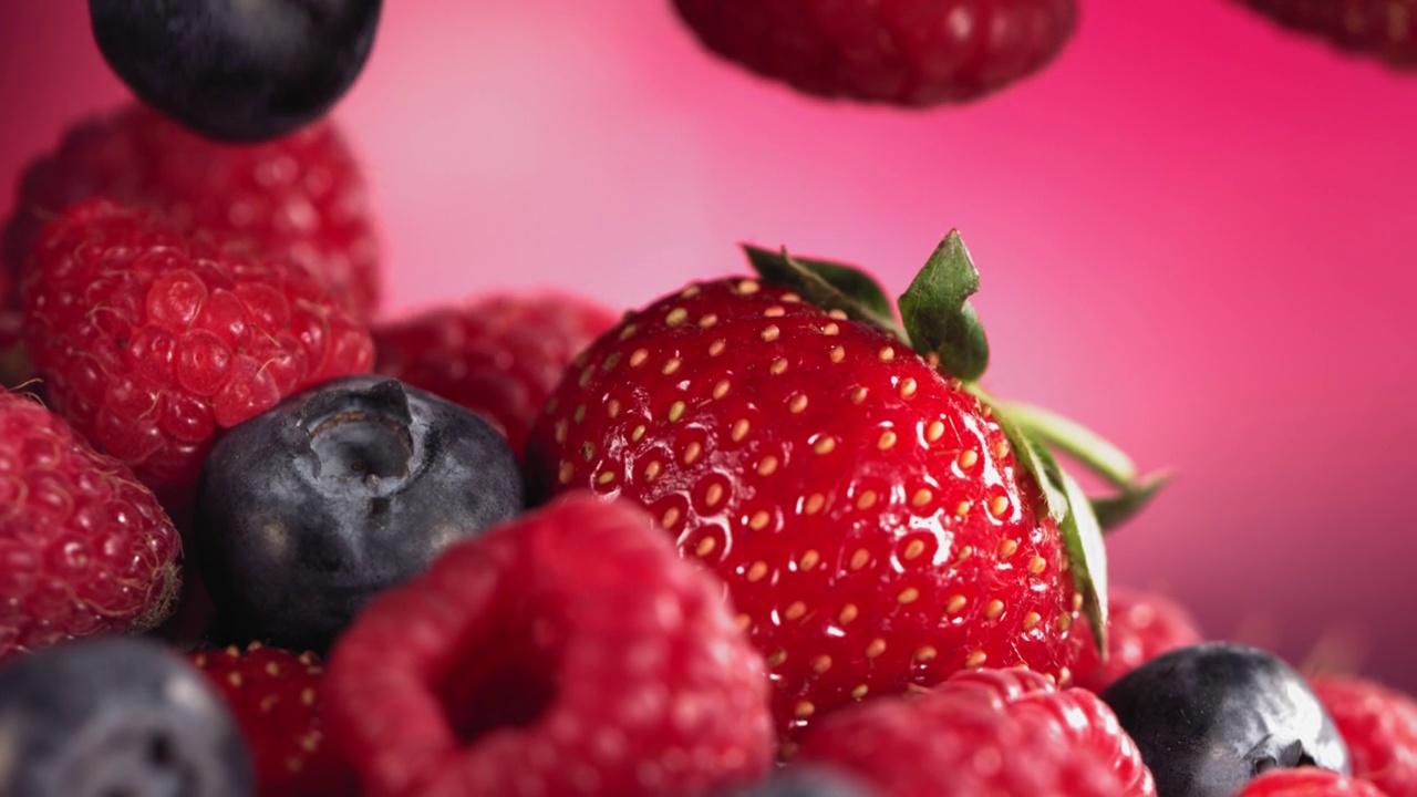 成熟多汁的草莓、蓝莓、覆盆子在许多混合浆果上面滚动视频下载