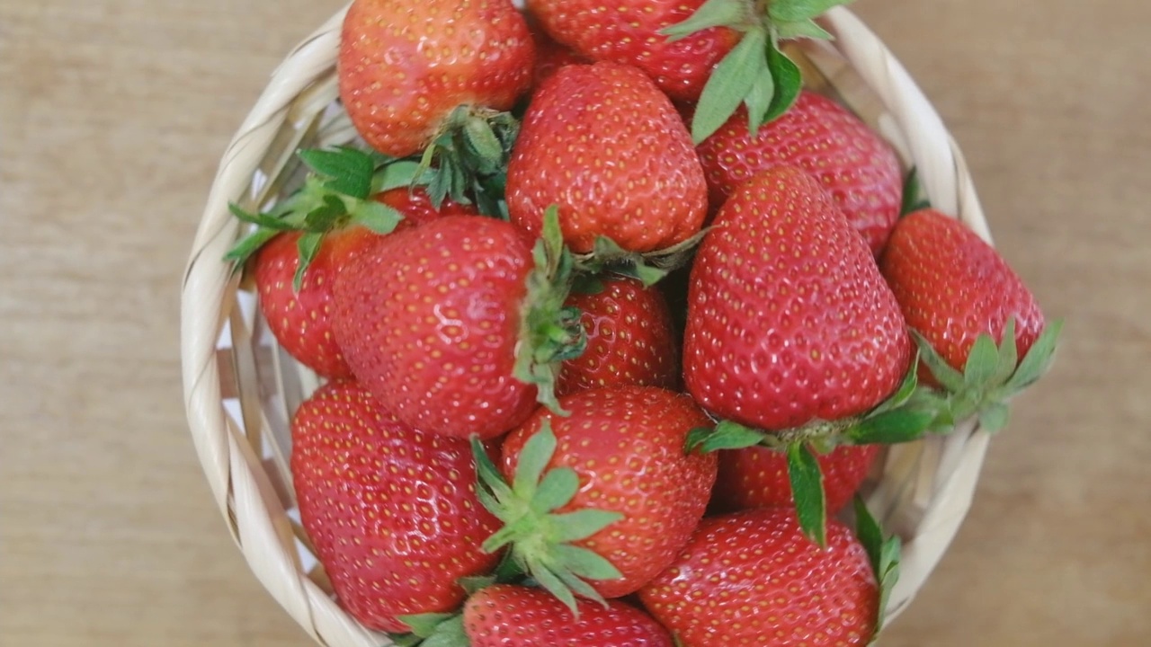 许多有机草莓在一个篮子里纺纱。视频下载