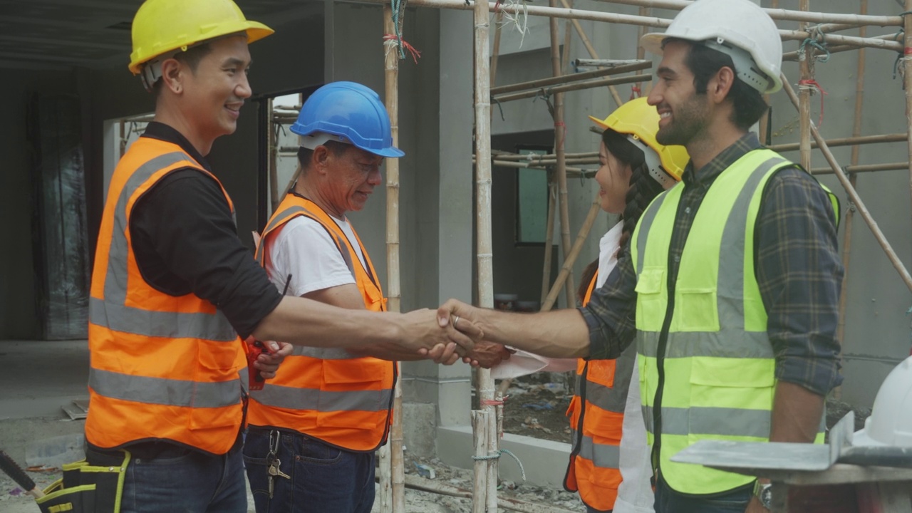 年轻的亚洲工头和工人为团队合作而握手，工程师和施工现场，建筑师为成功而握手，关于协议和共同处理。视频素材