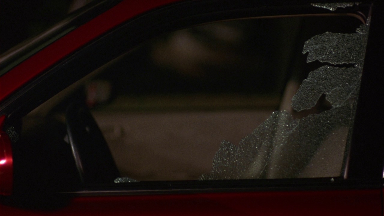 一辆红色汽车司机侧窗的中等角度。看见有人跑过去打破窗户视频素材
