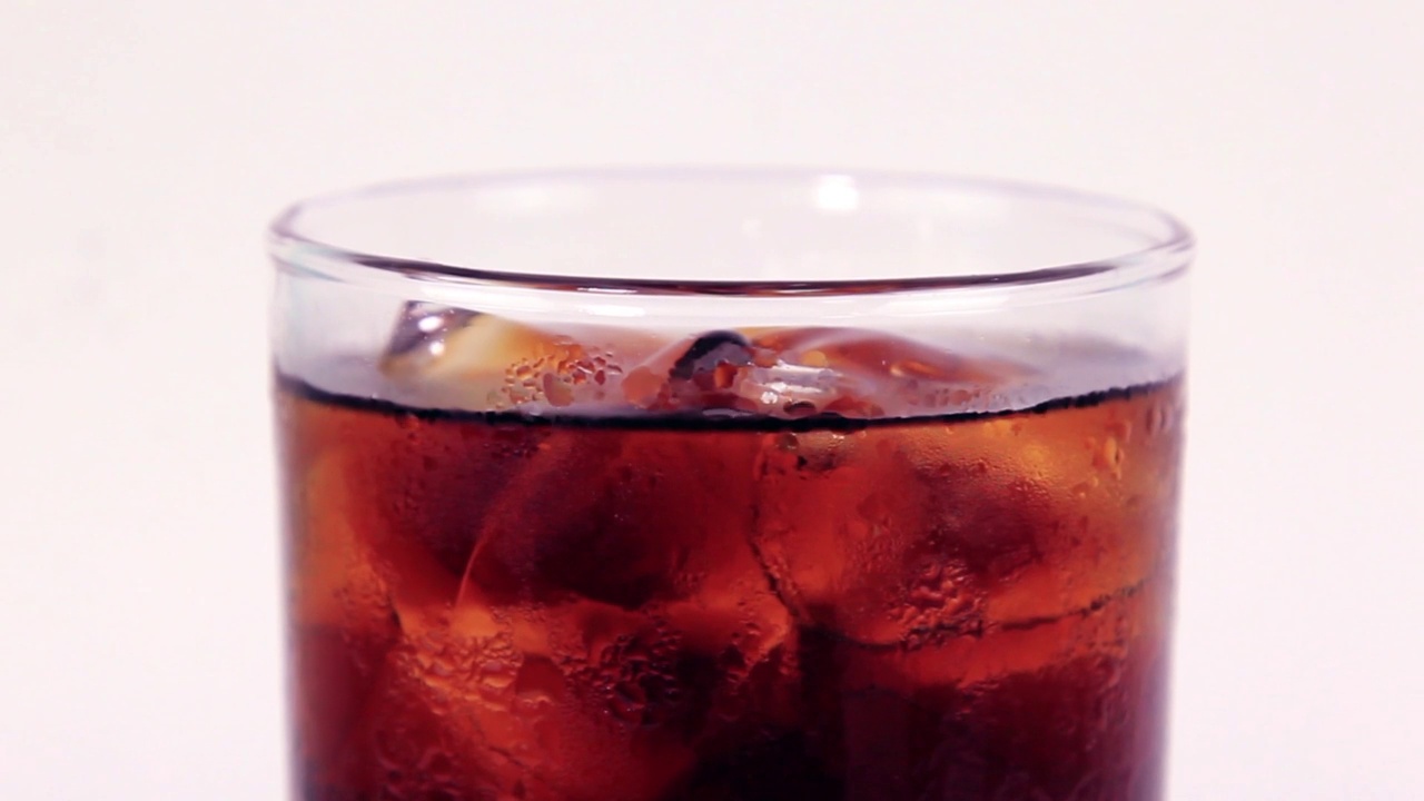 移动杯可乐与冰填补黑色可乐在白色背景在中心视频下载