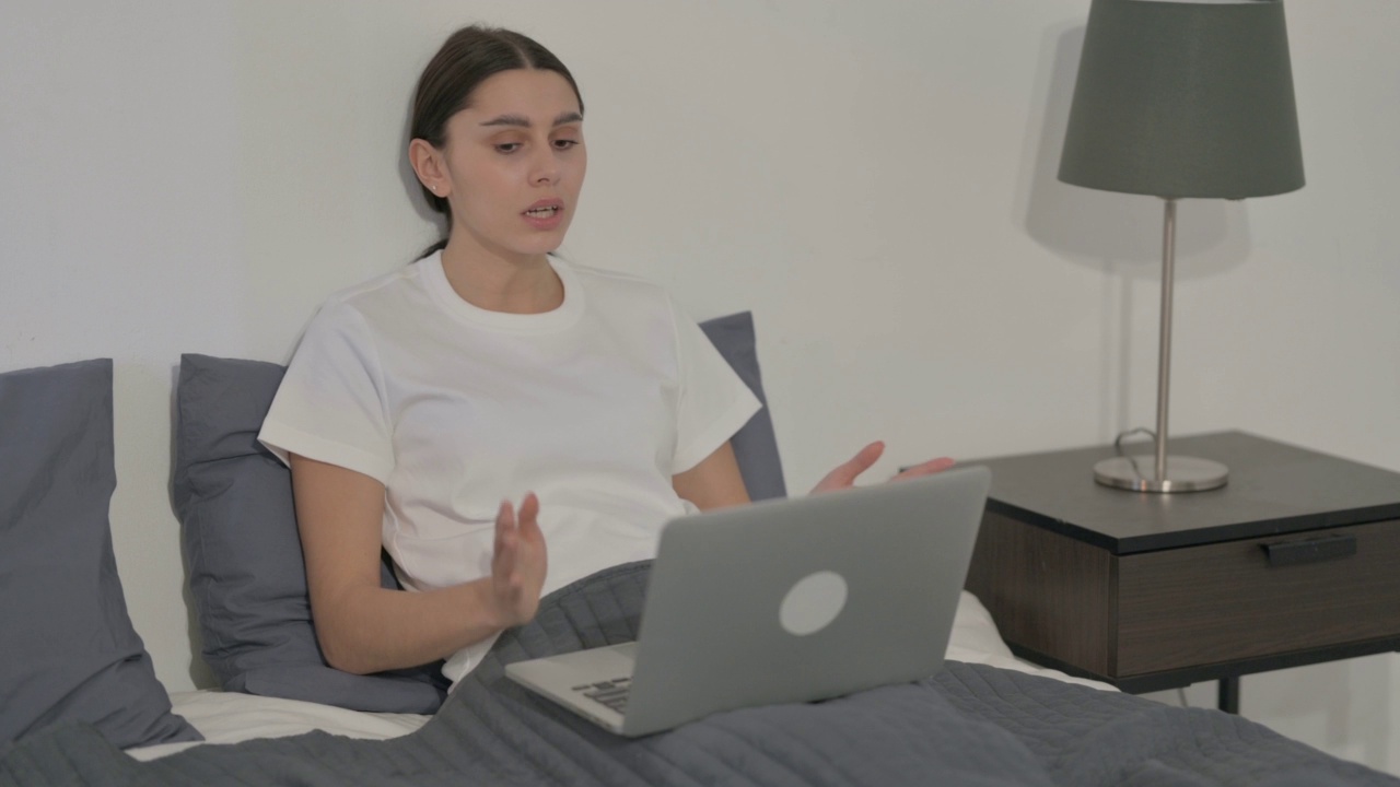 西班牙女性对在床上丢失笔记本电脑的反应视频素材