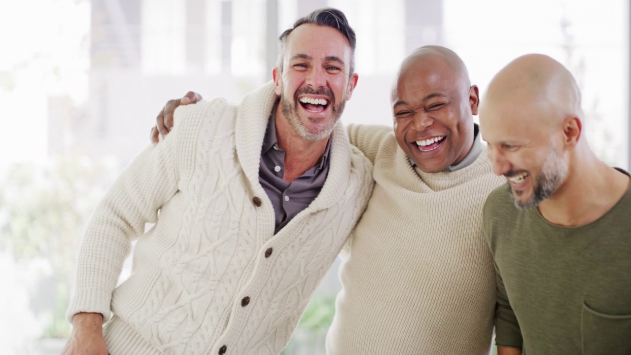 三个不同的男人团结地站在一起，微笑着，大笑着，展示着他们团结在一起的力量。不同种族的朋友群体表达兴奋，成功和胜利对光明的copyspace视频下载