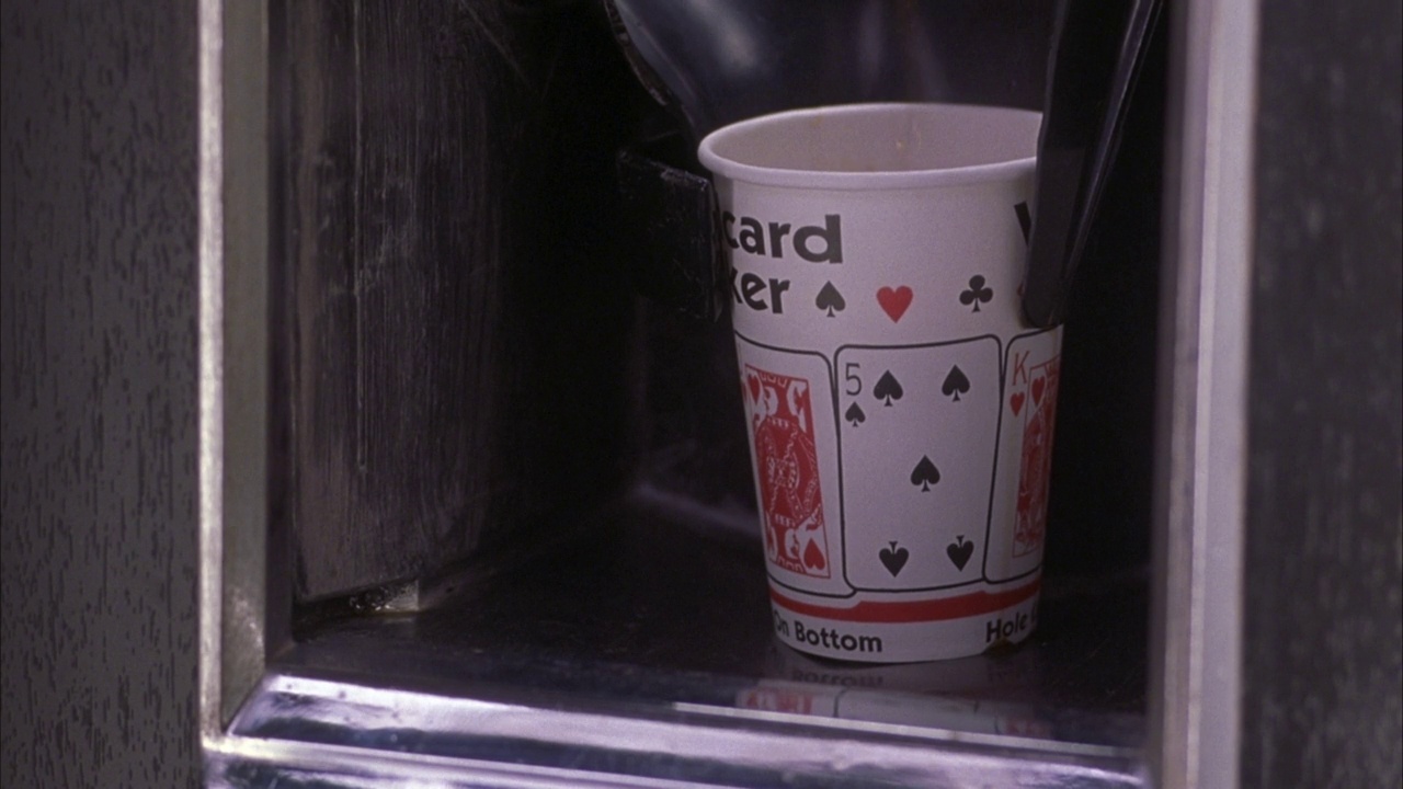 咖啡自动贩卖机中角黑色杯子释放。见白纸咖啡杯从pov滴入咖啡杯释放区。看咖啡从上面倒进杯子。见文字杯阅读“通配符扑克”和扑克牌的一面的杯子视频素材